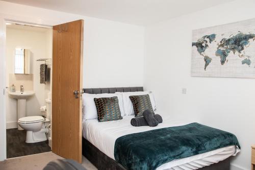a bedroom with a bed and a bathroom with a toilet at PENTHOUSE - LIVERPOOL City Centre & Royal Hospital Location in Liverpool