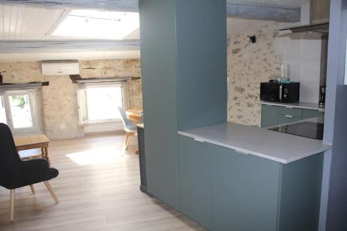 a kitchen with a counter and a table in a room at Gîte Lou Granié in Nyons