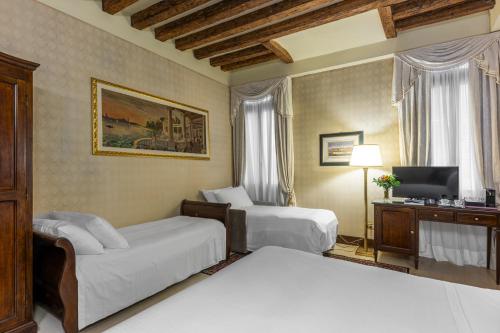 ein Hotelzimmer mit 2 Betten und einem TV in der Unterkunft Ca' Del Nobile in Venedig