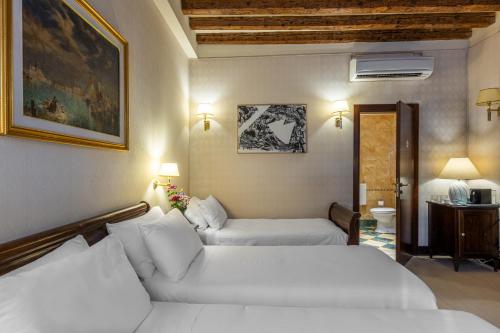 a hotel room with two beds and a couch at Ca' Del Nobile in Venice