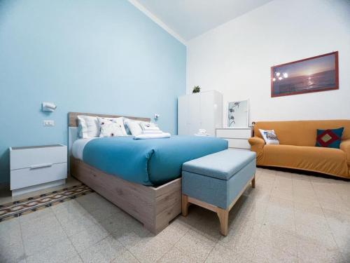 een slaapkamer met een blauw bed en een bank bij A casa di Ala in Rome
