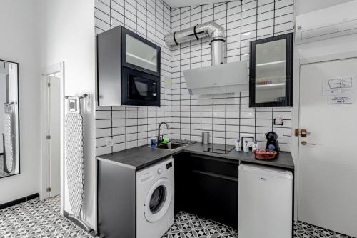 eine Küche mit einer Spüle und einer Waschmaschine in der Unterkunft Apartamentos Pino in Benidorm