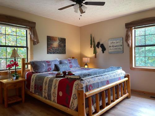 um quarto com uma cama e uma ventoinha de tecto em Rustic Cabin, Fire Pit with HotTub, Mountain Views, Peaceful Location em Sevierville