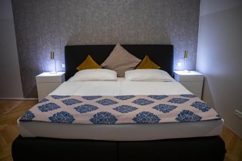 a bedroom with a large bed with two lamps at VotivPark Vienna Serviced Apartments in Vienna