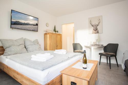 een slaapkamer met een bed en een fles wijn bij Deluxe Studio - City Center - 5 Min to Slopes - Am Kurpark in Winterberg