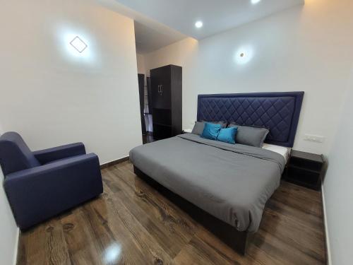 1 dormitorio con 1 cama y 1 silla azul en Kodai Outdoor Valley, en Kodaikanal