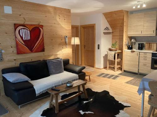 a living room with a couch and a heart painting on the wall at Chalet GAIA im Bergdorf Berwang in Berwang