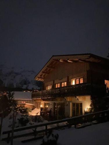 a house in the snow at night at Chalet GAIA im Bergdorf Berwang in Berwang