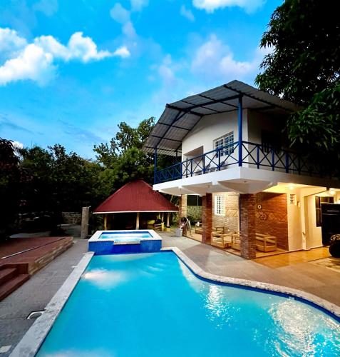 a villa with a swimming pool in front of a house at Nature villa Bonao in Bonao