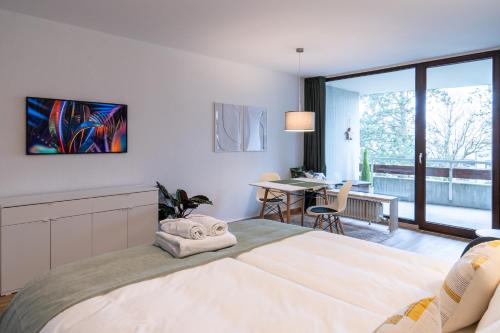 a bedroom with a large bed and a dining room at MESSE und UNI-Nähe: Moderne Wohnung mit Parkplatz und Küche in Augsburg