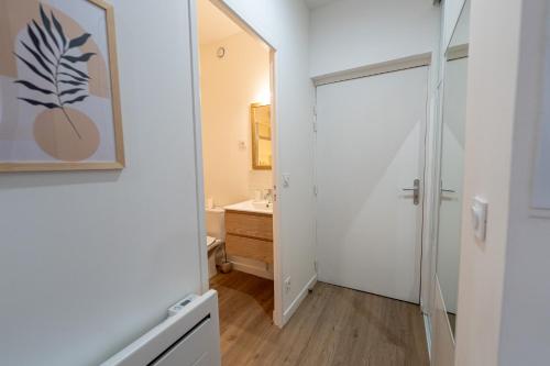 een badkamer met een wastafel en een spiegel bij Le petit Giennois in Gien