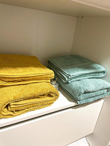 2 piles de serviettes assises sur une étagère dans un placard dans l'établissement Appartement entier en cœur de ville, à Sète