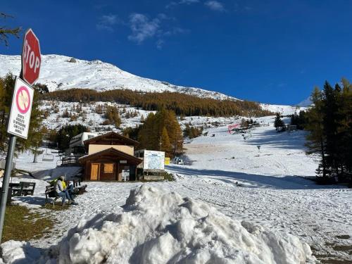 une pile de neige à côté d'un panneau d'arrêt sur une piste de ski dans l'établissement Appartamento Fondo Valle a 1 minuto dalle piste, à Madesimo