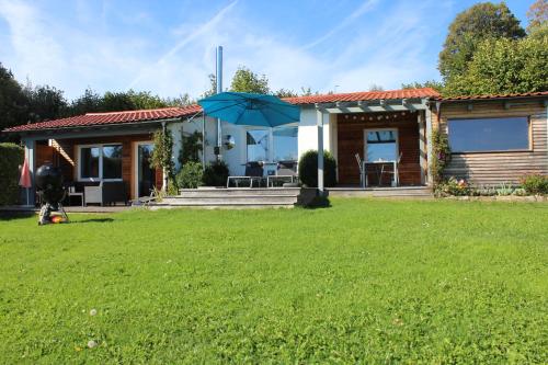 a small house with an umbrella in a yard at Ferienhaus Schau ins Land - eigene Panorama-Sauna in Schöfweg