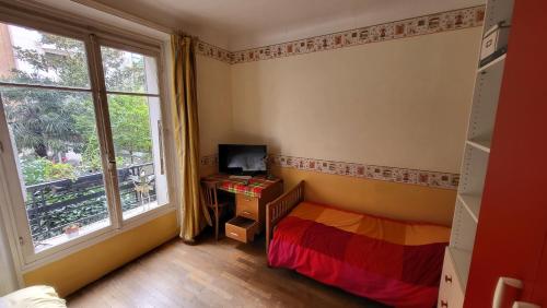 a small bedroom with a bed and a window at Le grand calme à deux pas de Paris in Neuilly-sur-Seine