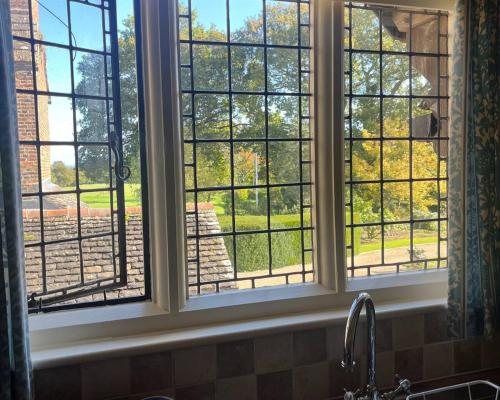 ein Küchenfenster mit Blick auf einen Hof in der Unterkunft Apartment in an historic farmhouse in Burgess Hill