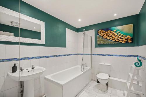 uma casa de banho branca com um lavatório e um WC em Beautiful Duplex with Private Rooftop - Sleeps 6 em Bristol