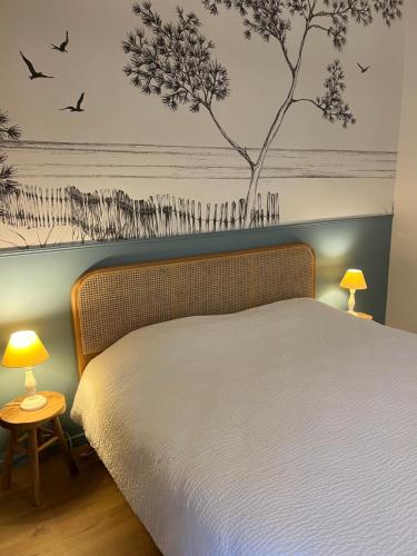 a bedroom with a bed with birds on the wall at La Chaumière de la Chaize in Saint-Jouan-des-Guérets