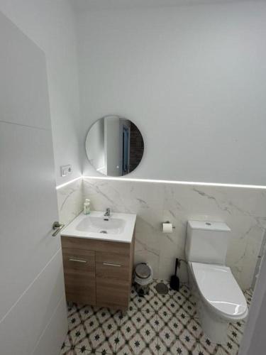 貝尼多姆的住宿－Apartamentos Rocablanca，一间带卫生间、水槽和镜子的浴室