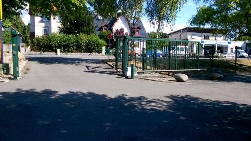 a gate on a street with a playground at Kyriad Mulhouse Est - Lutterbach in Lutterbach