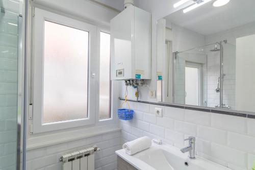 baño blanco con lavabo y ventana en APARTAMENTO HOLIDEA CALLE BONIFAZ, en Santander