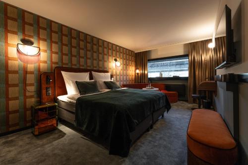 The Home Hotel Zürich - a member of DESIGN HOTELS في زيورخ: غرفه فندقيه بسرير واريكه