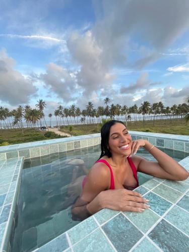 a woman is sitting in a swimming pool at Reserva do Paiva suites in Cabo de Santo Agostinho