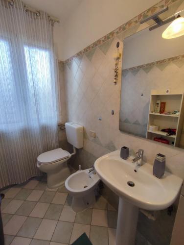a bathroom with a sink and a toilet and a mirror at House Viareggio in Viareggio