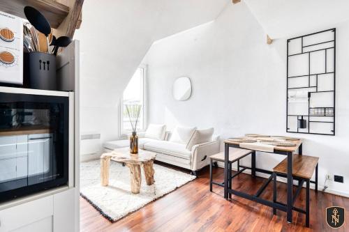 a living room with a white couch and a table at L'Atypique — Duplex de charme in Caen