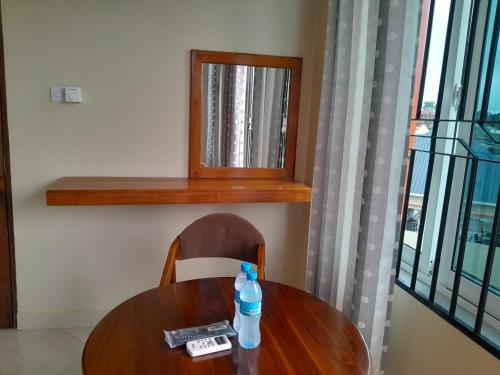 a wooden table with a bottle of water on a chair at WILIVINA HOTEL in Dar es Salaam
