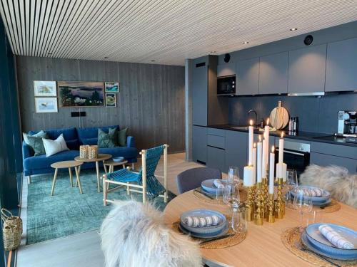 a kitchen and dining room with a table and a couch at Waterfront apartment with panoramic sea view in Henningsvær