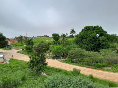 a dirt road in the middle of a field with trees at WILIVINA HOTEL in Dar es Salaam
