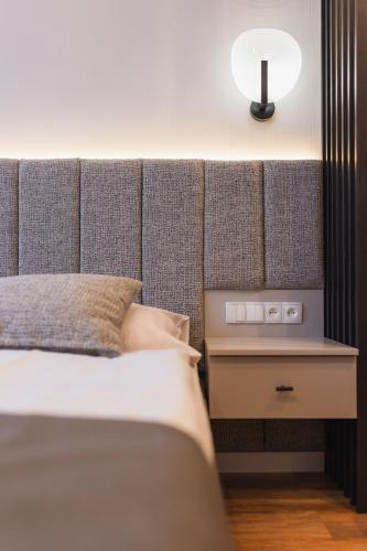 a bedroom with a bed with a headboard and a lamp at Dom Wypocz Pod Litwinką Apartamenty in Białka Tatrzanska