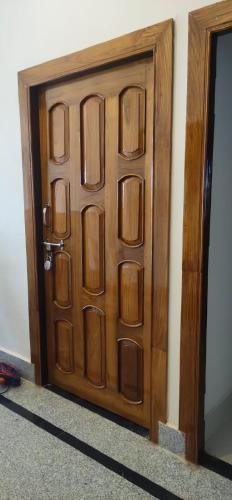 a wooden door in the corner of a room at Purna Brahma Vatika in Deoghar