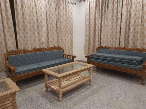 a room with three couches and a coffee table at Purna Brahma Vatika in Deoghar