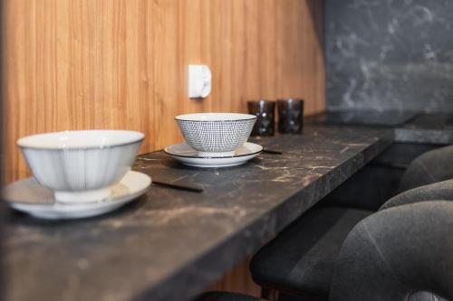 two bowls and plates on a counter with chopsticks at Dom Wypocz Pod Litwinką Apartamenty in Białka Tatrzanska