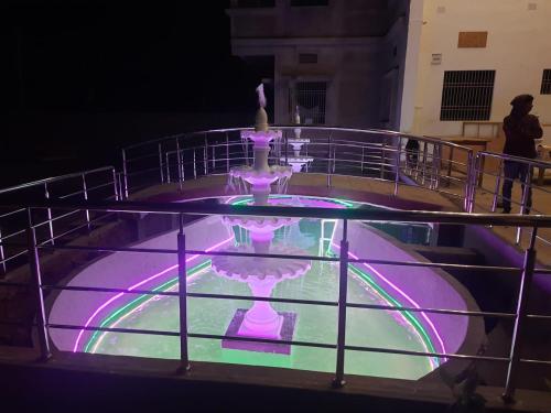 a fountain with purple and green lights on it at Purna Brahma Vatika in Deoghar