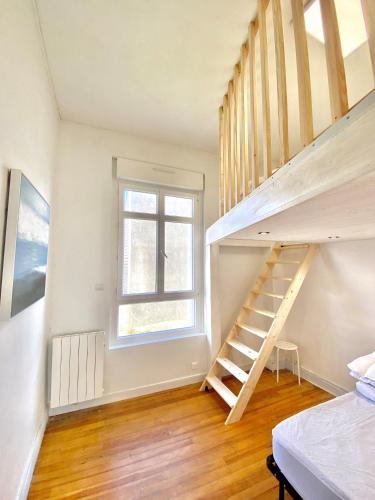 une chambre avec un escalier et une fenêtre dans l'établissement Appartement vue mer Merlimont, à Merlimont
