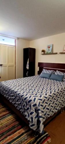 1 dormitorio con 1 cama grande con almohadas azules en Habitación totalmente independiente con cocina, baño, balcón super espacioso, en Arequipa
