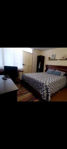 - une chambre avec un lit et un bureau dans l'établissement Habitación totalmente independiente con cocina, baño, balcón super espacioso, à Arequipa