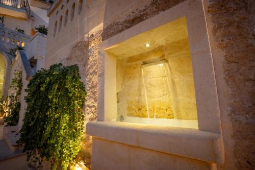 a window in a stone wall with a plant at Tufo Bianco Relais in Massafra