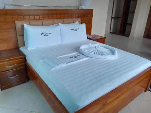 a bed with two pillows and towels on it at WILIVINA HOTEL in Dar es Salaam