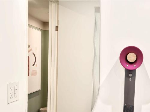 a bathroom with a pink mirror next to a door at 东京上野超级中心 设计师房间Ybob 上野公园3分钟 车站1分钟 超级繁华 免费wifi 戴森吹风 in Tokyo