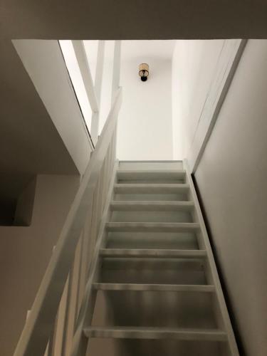 a staircase leading up to a room with a light at Joli duplex in Dijon