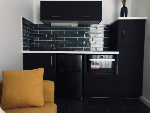 a kitchen with black cabinets and a sink and a oven at Joli duplex in Dijon