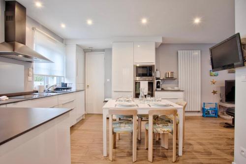 La Casa Bella - Calm and cosy house by the sea في اويسترهام: مطبخ مع طاولة وكراسي في مطبخ