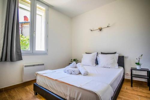 Schlafzimmer mit einem Bett mit weißer Bettwäsche und einem Fenster in der Unterkunft 21 Centre Historique - Gare- Place de la Comédie in Montpellier