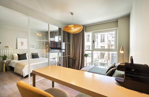 uma sala de estar com uma cama e uma mesa num quarto em 9 Muses Exclusive Suites In Syntagma em Atenas