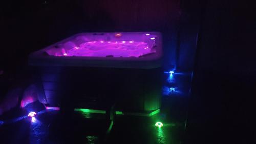 una bañera púrpura con luces en una habitación oscura en Casa Mendez, en Buseto Palizzolo