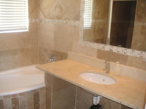 un baño con lavabo y bañera en Waterside Living MM1404, en Jeffreys Bay